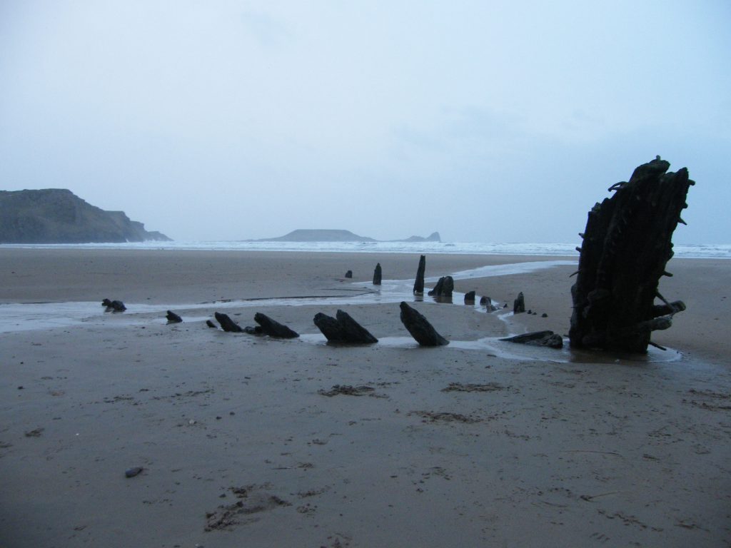 The Helvetia shipwreck showing above the sand at low tide on Rhossili beach.