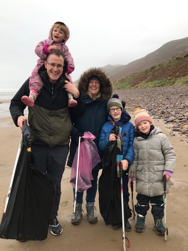 Family enjoying a litter pick on the beach.
