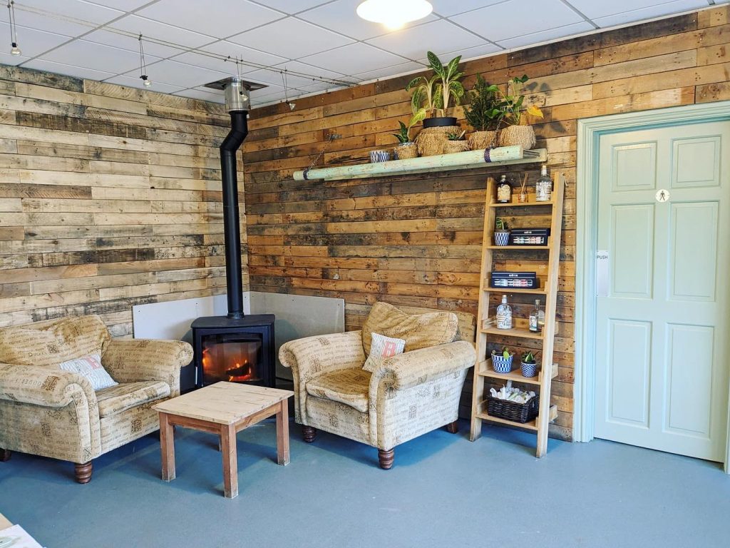 Refurbished corner of the bistro with two comfy armchairs and log burning stove