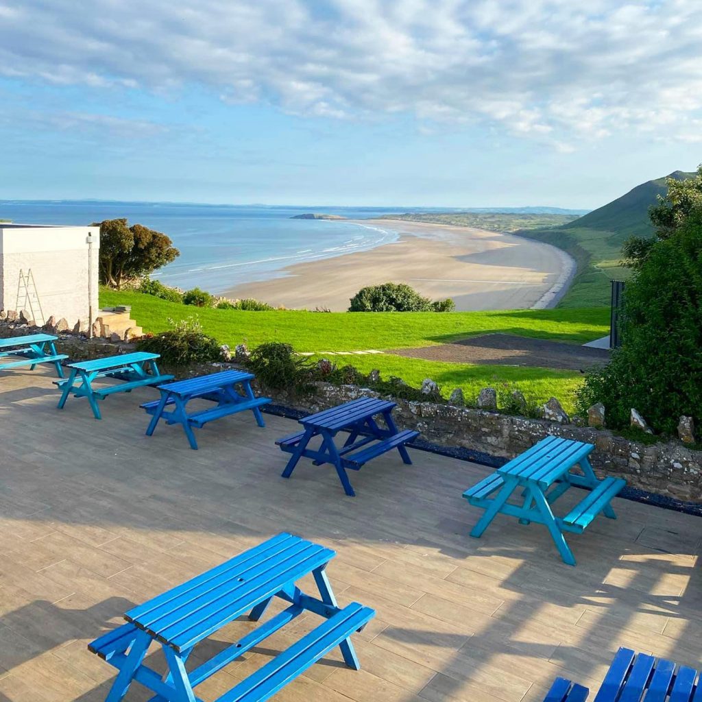 View from the Bay Bistro terrace with picnic benches overlooking Rhossili Bay.