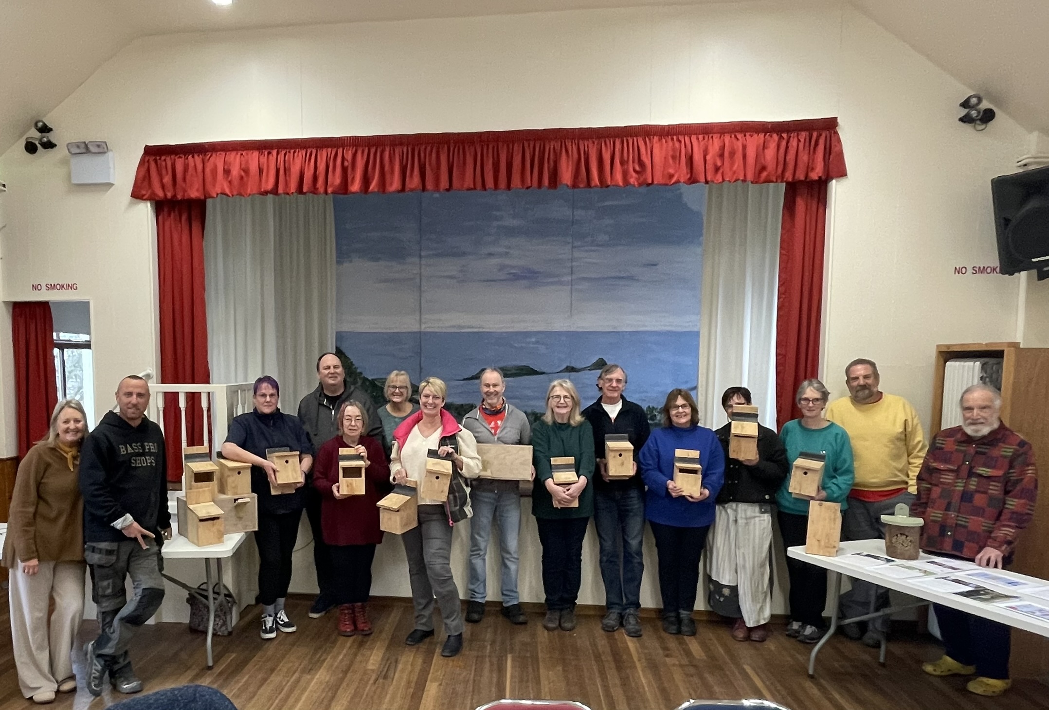 Line-up of people who attended the bird box workshop, holding the boxes they made
